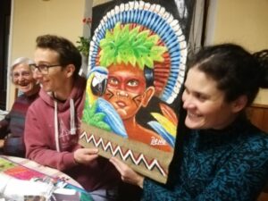 Arnaud et Elodie avec la toile peinte représentant un indien d'Amazonie
